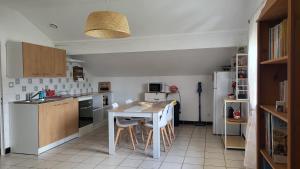 a kitchen with a table and chairs in a room at les chambres de Mélis in Crémieu +16 photos