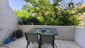 a table and two chairs on a patio at John & Mary's House Kalivia Near Sea & Athens Airport in Kalívia Thorikoú