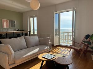 a living room with a couch and a table at T h e - P L A I C E in Wimereux