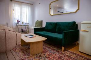 a living room with a green couch and a table at Hotel Salatia in Alcácer do Sal