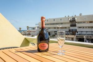 a bottle of wine and a glass on a table at Addict Heliopolis Luxury and Sensual Apartment in Cap d'Agde