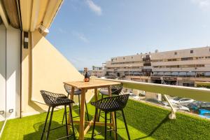 a table and chairs on the balcony of a building at Addict Heliopolis Luxury and Sensual Apartment in Cap d'Agde