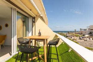 a table and chairs on a balcony with a view of the ocean at Addict Heliopolis Luxury and Sensual Apartment in Cap d'Agde