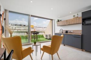 a kitchen with yellow chairs and a large window at Addict Heliopolis Luxury and Sensual Apartment in Cap d'Agde +12 photos