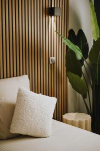 a pillow sitting on a bed next to a plant at Da Lisa wellness spa proche centre ville in Reims +14 photos