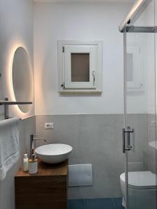 a bathroom with a sink and a toilet and a mirror at Casa Vacanze Marinella Beach in San Vito lo Capo