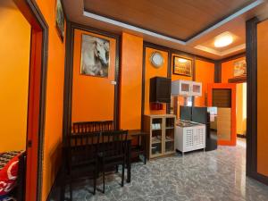 a room with orange walls and a dining room at 2 Bedroom Near Shops & Stores in Cebu City
