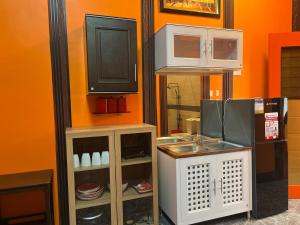 a tv sitting on top of a wall next to a kitchen at 2 Bedroom Near Shops & Stores in Cebu City