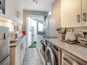 a kitchen with a washer and dryer at Daisy Cottage in Shaldon