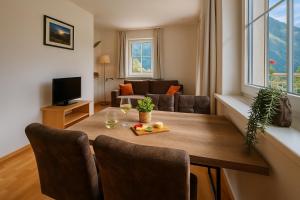 a living room with a wooden table with chairs and a couch at Appartementhaus Flattach in Flattach