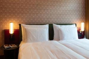a bedroom with a bed with white sheets and pillows at Cresta Palace Celerina in Celerina