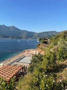 a view of a beach with the ocean and mountains at Apartmani Suzanna  +12 photos