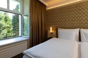 a bedroom with a white bed and a window at Cresta Palace Celerina St Moritz active-in and experience-out in Celerina +62 photos