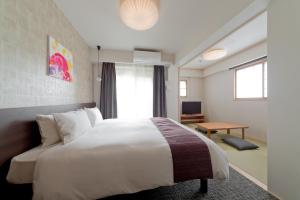 a hotel room with a large bed and a desk at M's Inn Higashiyama in Kyoto