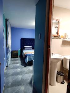 a blue room with a bed and a sink at La Casa del NONO in Cajamarca +31 photos