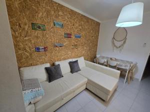 a living room with a white couch and a wall with pictures at Zen House Casa de Aldeia in Santo António da Terrugem
