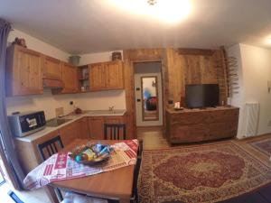 a kitchen with wooden cabinets and a table and a television at Appartamento Pré-Saint-Didier, terme in Pré-Saint-Didier