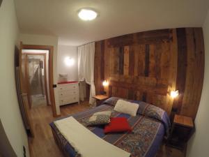 a bedroom with a large bed with a wooden wall at Appartamento Pré-Saint-Didier, terme in Pré-Saint-Didier