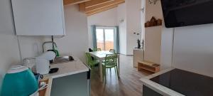 a kitchen with a sink and a table in a room at Dream Apartments Moena in Moena