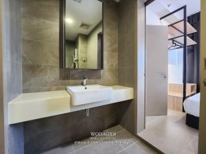 a bathroom with a white sink and a mirror at Mossaz at Empire Damansara by Wodages in Kuala Selangor