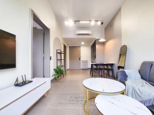 a living room with a couch and a table at Mossaz at Empire Damansara by Wodages in Kuala Selangor
