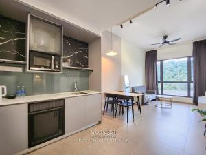 a kitchen and living room with a table and chairs at Mossaz at Empire Damansara by Wodages in Kuala Selangor