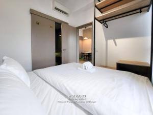 a white bed with a towel on top of it at Mossaz at Empire Damansara by Wodages in Kuala Selangor