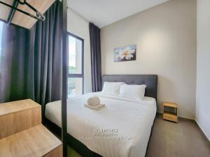 a bedroom with a bed with a hat on it at Mossaz at Empire Damansara by Wodages in Kuala Selangor