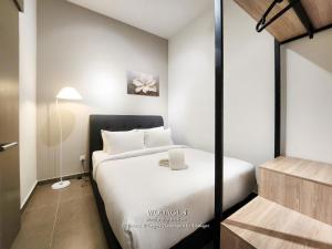 a bedroom with a white bed and a lamp at Mossaz at Empire Damansara by Wodages in Kuala Selangor