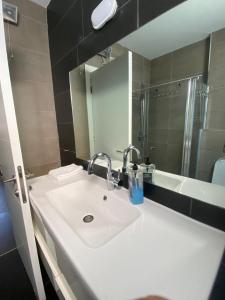 a bathroom with a white sink and a shower at Studio at the Kibbutz in Ashdot Ya‘aqov +16 photos