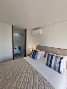 a bedroom with a large bed with blue and white pillows at Espinho Charm Stay in Espinho