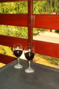 two glasses of red wine sitting on a table at Sunny Slope cottage-vikendica "Sunčana padina" in Berane