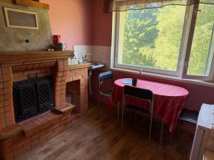 a dining room with a table and a fireplace at Cozy Apt in Haanja in Haanja +4 photos