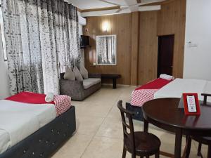 ウナワトゥナにあるManidi Villaのベッド2台とテーブルがあるホテルの部屋