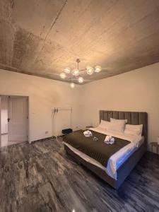 a bedroom with a large bed and a wooden floor at The Cave Garden in Cluj-Napoca