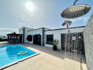 una casa con piscina delante de una casa en Villa Ocean Lanzarote, en Playa Blanca