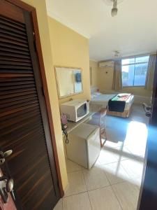 a hotel room with a bed and a microwave at Pousada Emaús in Cruzeiro +30 photos