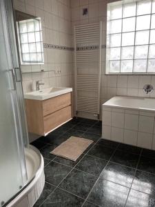 a bathroom with a sink and a tub and a shower at Ferienwohnung Sonnenschein in Kappel-Grafenhausen