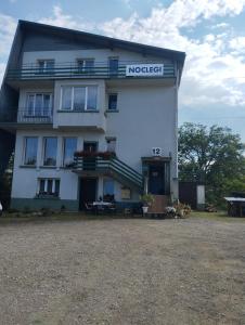a white building with a sign on the side of it at Pokoje gościnne Jacek in Polańczyk