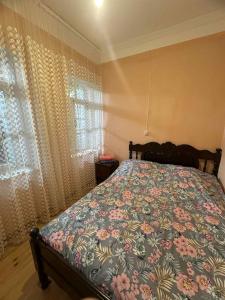 a bedroom with a bed with a floral bedspread at Century House of Larisa in Mestia +58 photos