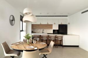a kitchen and dining room with a wooden table and chairs at דירת חוף נתניה in Netanya