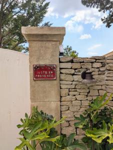 a sign on the side of a stone wall at Juste en Provence in Saint-Saturnin-les-Apt