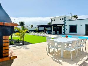 un patio con una mesa blanca y sillas blancas en Villa Ocean Lanzarote, en Playa Blanca 49 fotos más