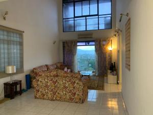 a living room with a couch and a large window at Urban bloom stays in Kuala Lumpur