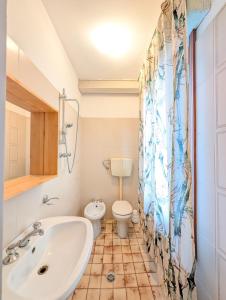 a bathroom with a sink and a toilet and a shower curtain at Locanda San Marco in Caorle