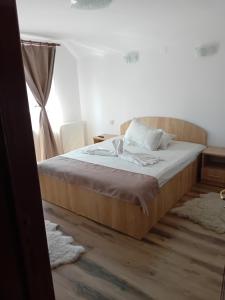 ein Schlafzimmer mit einem Bett mit hölzernem Kopfteil in der Unterkunft Casa Marylo in Bran