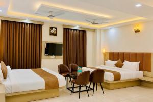 a hotel room with two beds and a table at Hotel Vasudevay Inn in Haridwār +29 photos