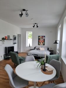 a living room with a bed and a table and chairs at 1-Zimmer-Loft Casa Frida in Walldürn