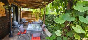 a patio with a table and chairs and vines at ANAHATA Appartement-Maison in Saint Paul de Vence