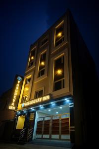 a building with an emergency inn lit up at night at Hotel Vasudevay Inn in Haridwār